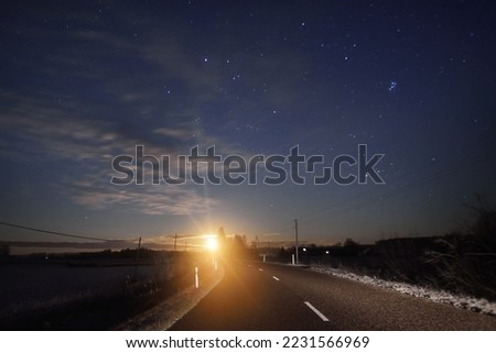 Highway at sunset. Dramatic twilight sky, midnight sun, starlight, moonlight. Dark atmospheric landscape. Panoramic view, copy space, art. Dangerous driving, loneliness, peace, freedom concepts