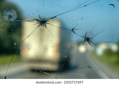 Highway through a broken windshield after encountering a truck with crushed stone. Challenging driving on Asian roads