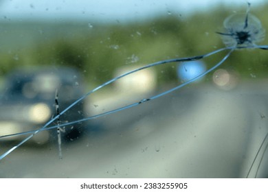 Highway through a broken windshield after encountering a truck with crushed stone. Challenging driving on Asian roads