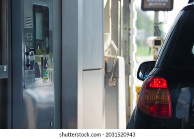 Highway toll station, collecting booth. Roadway with car drivers needing to pay tolls to pass. Driver pays for the fare on toll station highway