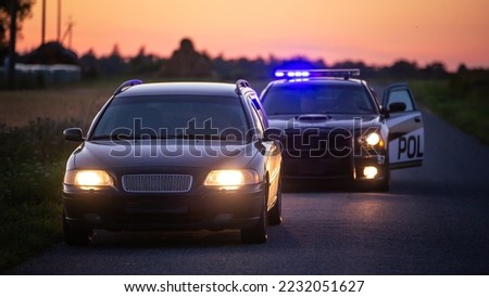 Highway Traffic Patrol Car Pulls over Vehicle Check on Empty Road. Police Officer Comes out of Car and Person for License and Registration, writes a Ticket. Cinematic Wide Angle Side View Shot
