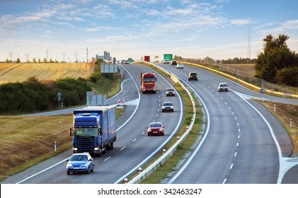 Highway traffic in sunset with cars and trucks