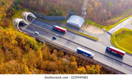 Highway tunnel in mountain. Traffic on the road. Transportation from above. Cars as a source of air pollution.