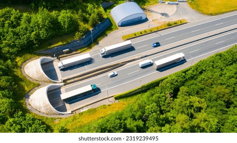 Highway tunnel in mountain. Traffic on the road. Transportation from above. Cars as a source of air pollution. - Powered by Shutterstock