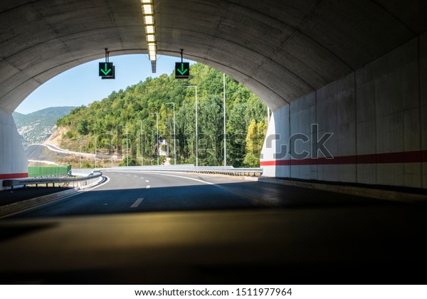 Highway tunnel. Signs in\
tunnel. Mountain road. Travel and traffic concept. View from inside\
the car.