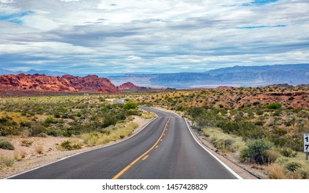 Highway in valley of fire Nevada, USA. Empty winding road, passing through American desert and valley red rocks, Blue cloudy sky background - Powered by Shutterstock