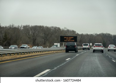 Highway View With Cars And An SUV Passing An Electronic Traffic Warning Sign That Flashes Drive Sober Or Get Pulled Over