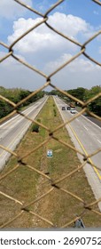 Highway View Through Rustic Chain Link Fence Mesh at Overpass