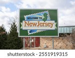 Highway welcome sign for New Jersey, featuring the state outline and bright colors. Positioned at a state entry point, the sign greets travelers entering New Jersey.