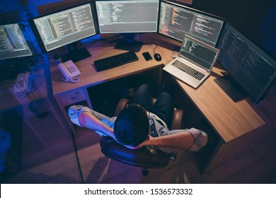 Hign angle above view photo of it skilled specialist guy sitting comfy office holding hands behind head looking many monitors testing team task finishing debugging