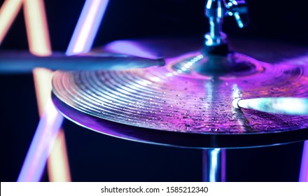 Hi-hat close-up of plates with drumsticks on a background of colored lanterns. Water drops on plates. Musical concept with a working drum. - Powered by Shutterstock