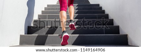 Hiit workout cardio running up the stairs training. Staircase climbing run woman going run up steps panorama banner. Runner athlete doing cardio sport workout. Activewear leggings and shoes.