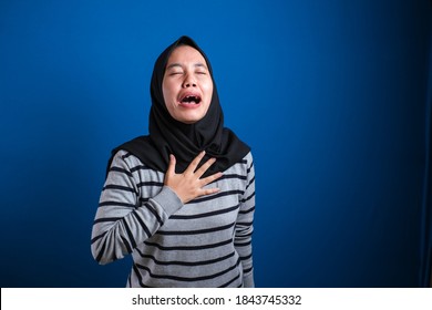 Hijab muslim girl is depressed and sad, she is crying, she close her eyes and hold her chest feeling the pain