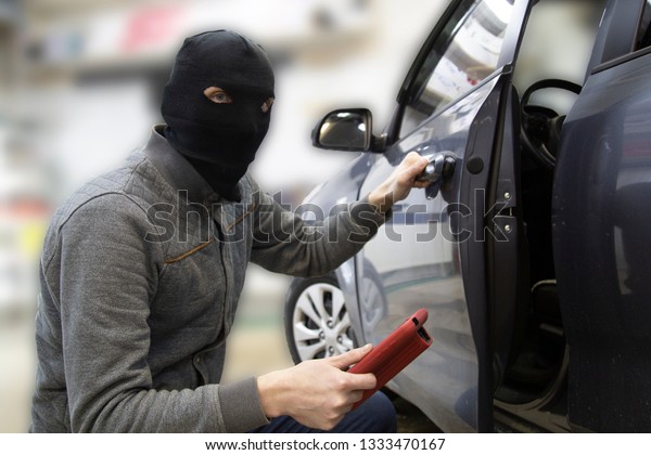 The hijacker tries to break into\
the car with a scanner. Code grabber . Car thief, car\
theft.