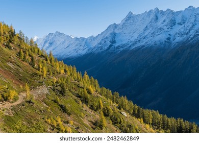 A hike in Lötschental in autumn reveals stunning alpine landscapes with vibrant fall foliage, snow-dusted peaks, serene mountain lakes, and charming Swiss chalets, all under crisp, clear skies - Powered by Shutterstock
