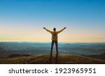 Hiker with arms up standing on the top of the mountain - Successful man enjoying triumph - Sport and success concept