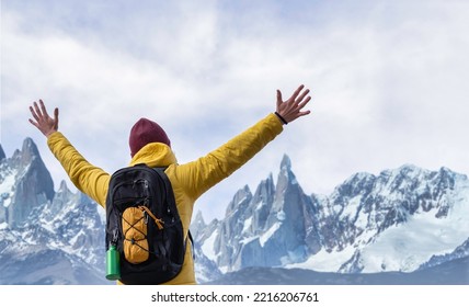 Hiker with arms up standing on the top of the mountain snowy  - Man enjoying and celebrating the triumph - Sport and travel concept - Shutterstock ID 2216206761