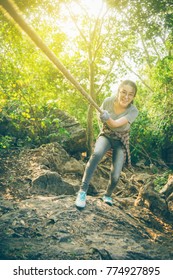 Hiker Asian Teenager Woman Enjoying To Climb The Rope To Hiking In The Wood. Fun With Free Time For Adventure. Exercise In Morning In Teen Hipster Concept. Filtered Image. Light Effect Added