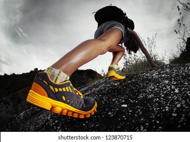 Hiker with backpack climbing rocky terrain. Focus on the boot - Powered by Shutterstock