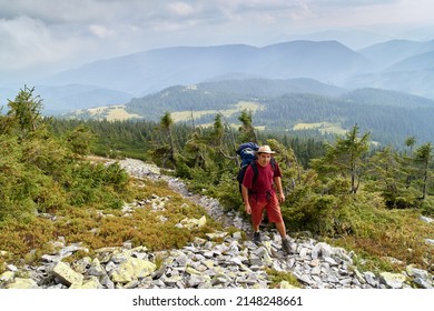 Hiker With Backpack Going Uphill. Hike In Carpathian Mountains. Hiker Going Up To The Mountain Peak On A Very Steep Trail. Lifestyle Concept Active Leisure Tourism