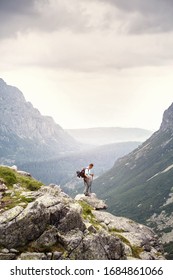 Hiker with backpack standing on top of a mountain. Lifestyle success concept adventure active vacations outdoor happiness freedom emotions. High Tatras mountains.