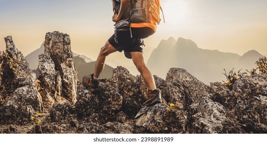 Hiker with backpack walking on top mountain sunset background. Hiker men's hiking living healthy active lifestyle.