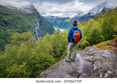 Hiker, Backpacker Standing On The Rock Above Geiranger Fjord In Norway