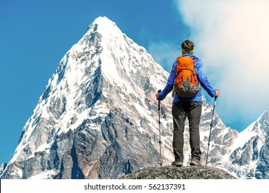 Hiker with backpacks reaches the summit of mountain peak. Success, freedom and happiness, achievement in mountains. Active sport concept.