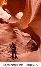 Hiker Basks In The Bronze Glow Of Lower Antelope Canyon Near Page, Arizona. Lake Powell Navajo Tribal Park.