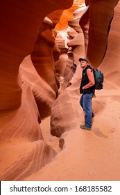 Hiker Basks In The Bronze Glow Of Lower Antelope Canyon Near Page, Arizona. Lake Powell Navajo Tribal Park.