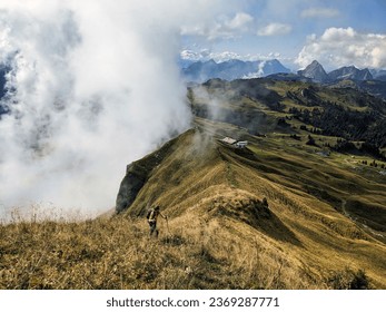 Hiker climbs the Forstberg near a sea of fog in Hoch Ybrig in the canton of Schwyz. Autumn hike with fog in the Swiss Alps. High quality photo
