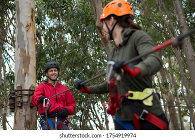 Hiker Couple Holding Zip Line Cable In The Forest During Daytime