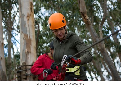 Hiker Couple Holding Zip Line Cable In The Forest During Daytime