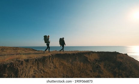 The hiker couple walking on a mountain against the beautiful sea view - Powered by Shutterstock