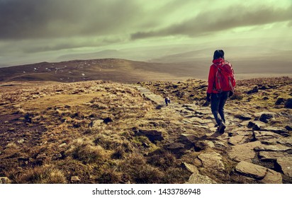 A hiker descending the summit of Ingleborough towards Simon Fell in the Yorkshire Dales, England. - Shutterstock ID 1433786948