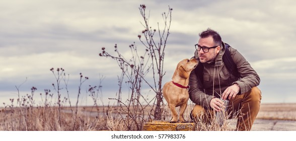 Hiker And Dog Resting On Old Brick Wall