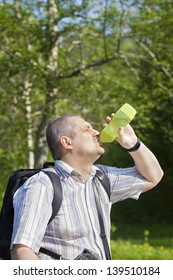 Hiker drinking water from bottle on forest trails