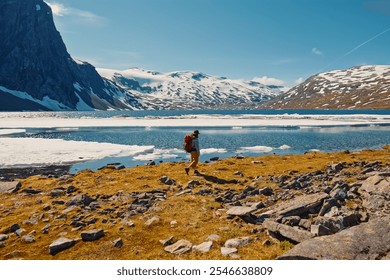 A Hiker Engaged in Exploring the Majestic and Beautiful Landscape by the Glacier Lake - Powered by Shutterstock