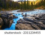 Hiker enjoying the view of Upper Sunwapta Falls in Jasper National Park, Alberta, Canada.