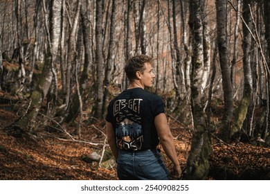 Hiker in the forest during autumn, laughing, enjoying, walking, wearing black t-shirt and red jacket and a backpack - Powered by Shutterstock