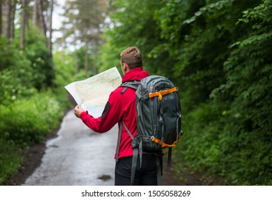 Hiker in a forest using map - Powered by Shutterstock