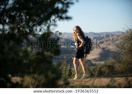 Hiker girl hiking mountain with backpack. Sporty girl looking at the stunning and wild landscape at panoramic point. Backpacking tourism