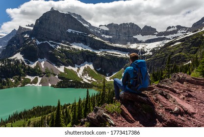 Hiker in glacier national park enjoying the view of Grinnell lake