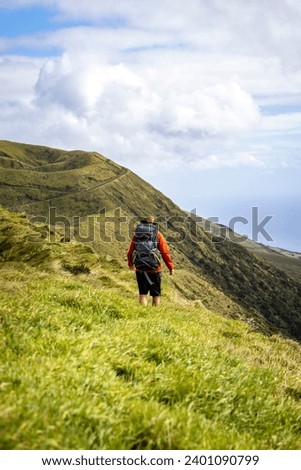 Hiker with a large Backpack Walking on a Hill on São Jorge Island in the Azores