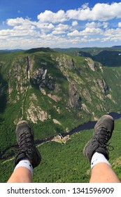 Hiker Legs And Boots At Acropoles De Draveurs Above The Canyon, Hautes-Gorges-de-la-Rivière-Malbaie National Park, Quebec In Canada