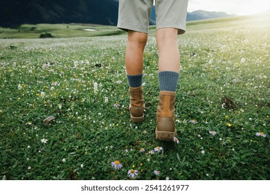 Hiker legs walking on beautiful flowering grassland - Powered by Shutterstock