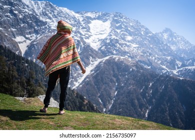 Hiker with local dress on the slope against the background of high snow-capped mountains of Triund Trek, Himachal Pradesh, India. - Shutterstock ID 2156735097