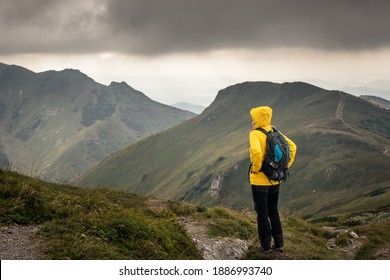 Wanderer sieht bewölkten Himmel über Gebirgskette. Frauen wandern bei schlechtem Wetter in den Bergen. Abenteuer in der Natur