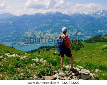 Hiker looking down to Walensee, lake Walen, St. Gallen, Switzerland.