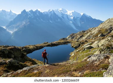 Hiker looking at Lac de Cheserys on the famour Tour du Mont Blanc near Chamonix, France. - Shutterstock ID 1203266659
